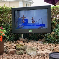 Un caja para television exterior en una zona de asientos al aire libre