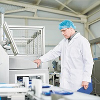 Un hombre usando un monitor industrial de fabricación de alimentos