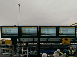 Cuatro carcasas para señalización digital para aeropuertos resistente a la intemperie en una parada de autobús